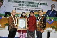Direktur Teknologi Informasi BPJS Kesehatan RI, Dr. Ir. Edwin Aristiawan menyerahkan piagam penghargaan kepada Bupati Sumenep Achmad Fauzi Wongsojudo disaksikan Direktur RSUD Dr. H. Moh. Anwar Sumenep dr. Erliyati dan Kepala BPJS Kesehatan Cabang Pamekasan Nuzuludin Hasan. (ISTIMEWA)