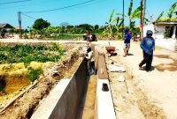 TERIK: Pekerja mengerjakan pembangunan saluran irigasi di Desa Jarin menuju Desa Pegagan, Kecamatan Pademawu, Pamekasan. (DINAS PUPR PAMEKASAN FOR KLIKMADURA)