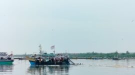 SANTAI: Nelayan Branta Pesisir, Kecamatan Tlanakan, Pamekasan menarik jaring di atas kapal. (LAILIYATUN NURIYAH/KLIK MADURA).