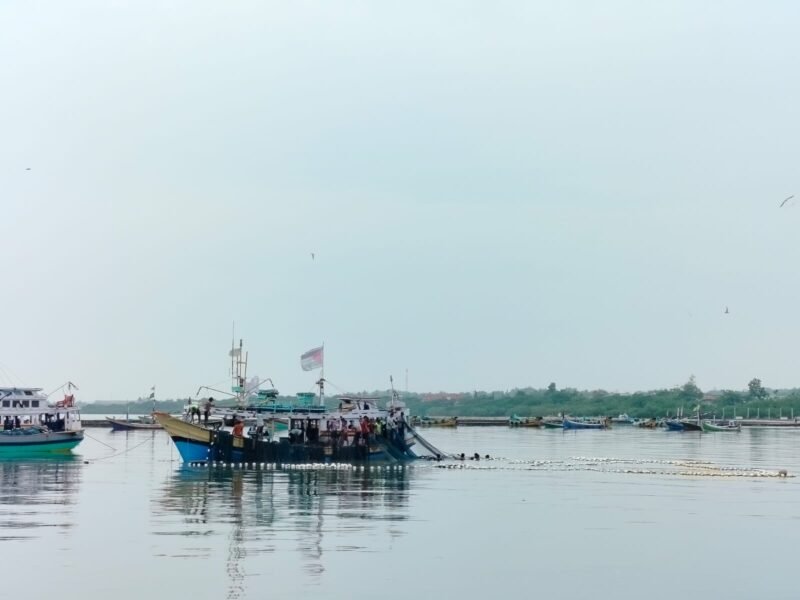 SANTAI: Nelayan Branta Pesisir, Kecamatan Tlanakan, Pamekasan menarik jaring di atas kapal. (LAILIYATUN NURIYAH/KLIK MADURA).