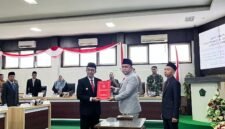 Ketua DPRD Pamekasan Ali Masykur menyerahkan dokumen hasil rapat paripurna kepada Bupati Pamekasan KH. Kholilurrahman di Ruang Rapat Paripurna, DPRD Pamekasan. (MOH. IQBALUL KHAVEI MZ / KLIKMADURA)