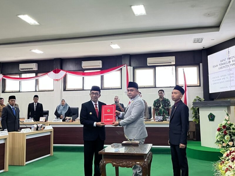 Ketua DPRD Pamekasan Ali Masykur menyerahkan dokumen hasil rapat paripurna kepada Bupati Pamekasan KH. Kholilurrahman di Ruang Rapat Paripurna, DPRD Pamekasan. (MOH. IQBALUL KHAVEI MZ / KLIKMADURA)