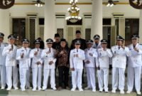 SOLID: Ketua Perkasa Kabupaten Pamekasan H. Pahrianto (tengah) foto bersama 11 kades usai pengukuhan perpanjangan jabatan di Mandhapa Agung Ronggosukowati. (PERKASA PAMEKASAN UNTUK KLIK MADURA).