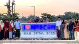 Peserta KKN Kelompok 3, STIT Al-Ibrohimy Bangkalan foto bersama di ikon nama desa yang baru dibangun. (ISTIMEWA)