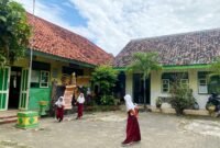 Siswi SDN Jungcancang 3 berada di halaman sekolahnya. (DOK. KLIKMADURA)