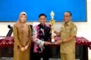 Moch. Yusron, S.Pi saat menerima penghargaan dari Kepala Disporabudpar Sampang, Marnilem. (ISTIMEWA)