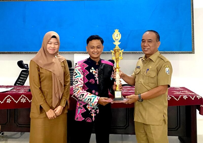Moch. Yusron, S.Pi saat menerima penghargaan dari Kepala Disporabudpar Sampang, Marnilem. (ISTIMEWA)