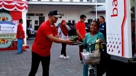 Pjs Pemimpin Cabang Bank Jatim Pamekasan, Yuda Imawan Sutanto menyerahkan nasi kotak kepada warga. (KLIKMADURA)