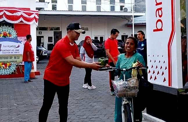 Pjs Pemimpin Cabang Bank Jatim Pamekasan, Yuda Imawan Sutanto menyerahkan nasi kotak kepada warga. (KLIKMADURA)