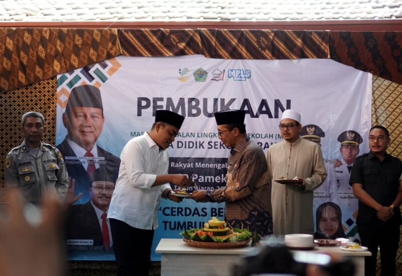 SUKSES: Bupati Pamekasan KH. Kholilurrahman menyerahkan tumpeng kepada Ketua DPRD Pamekasan Ali Masykur saat pembukaan MPLS SRMP 29 Pamekasan. (YUSRIL RAHMAN SYAKUR / KLIK MADURA).