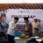 SUKSES: Bupati Pamekasan KH. Kholilurrahman menyerahkan tumpeng kepada Ketua DPRD Pamekasan Ali Masykur saat pembukaan MPLS SRMP 29 Pamekasan. (YUSRIL RAHMAN SYAKUR / KLIK MADURA).