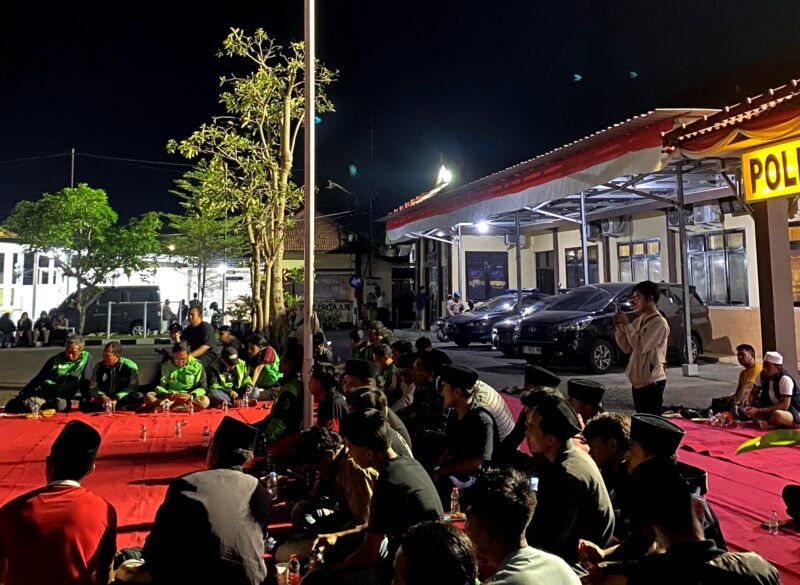 Mahasiswa dan ojol saat menggelar aksi damai di depan Mapolres Sampang. (IBNU ANSORI / KLIKMADURA)