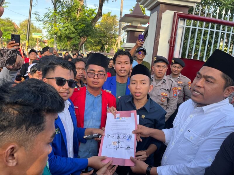 Ketua DPRD Pamekasan, Ali Masykur didampingi pimpinan dewan lainnya menyerahkan berkas berisi tuntutan mahasiswa yang ditandatangani. (MOH. IQBALUL KHAVEI MZ / KLIKMADURA)