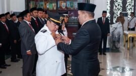 Bupati Sampang H. Slamet Junaidi menyematkan pin tanda jabatan saat pelantikan. (HUMAS PEMKAB SAMPANG FOR KLIKMADURA)