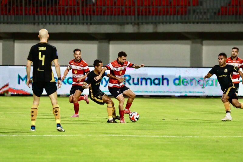 Penggawa Madura United berebut bola dengan pemain Bhayangkara FC dalam laga lanjutan Super League di SGMRP Pamekasan. (MOH. IQBALUL KHAVEI MZ / KLIKMADURA)