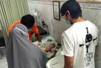 Tenaga kesehatan saat memeriksa kondisi bayi yang ditemukan di area pemakaman Desa Bulangan Barat, Kecamatan Pegantenan, Pamekasan. (POLRES PAMEKASAN UNTUK KLIKMADURA)