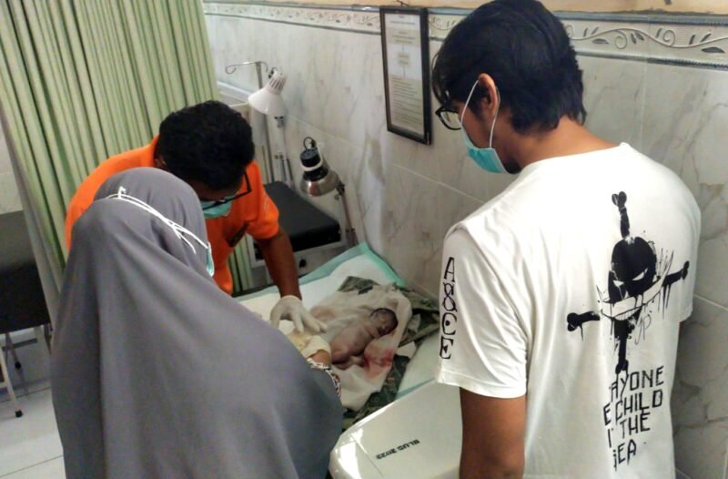 Tenaga kesehatan saat memeriksa kondisi bayi yang ditemukan di area pemakaman Desa Bulangan Barat, Kecamatan Pegantenan, Pamekasan. (POLRES PAMEKASAN UNTUK KLIKMADURA)