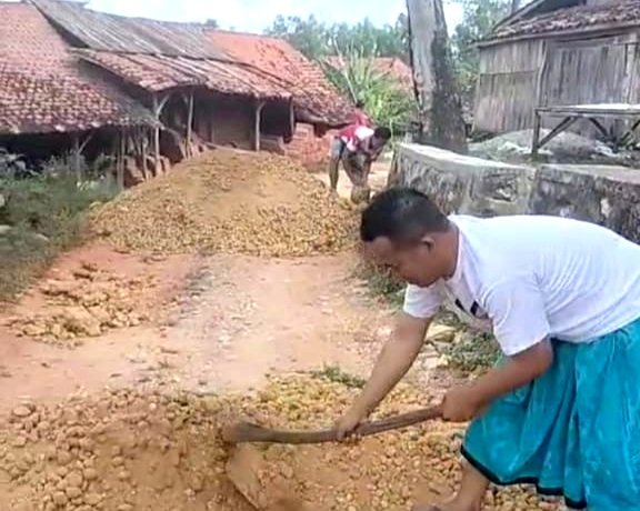 Warga Desa Gunung Kesan, Kecamatan Karang Penang, Sampang saat memperbaiki jalan dengan swadaya. (ISTIMEWA)