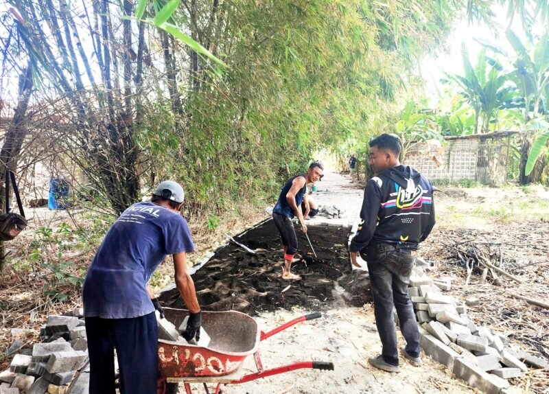 PROSES: Sejumlah pekerja melanjutkan proyek pavingnisasi di Desa Artodung, Kecamatan Galis, Pamekasan. (DPRKP PAMEKASAN FOR KLIKMADURA)