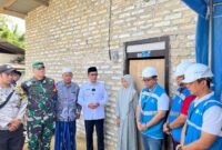 Bupati Pamekasan KH. Kholilurrahman (baju putih) didampingi Assistant Manager Keuangan dan Umum PLN UP3 Madura, Kharisma Nur Khakim berbincang usai penyerahan bantuan secara simbolis kepada Kamilah, guru honorer asal Desa Pamaroh, Kecamatan Kadur, Pamekasan. (KLIKMADURA)