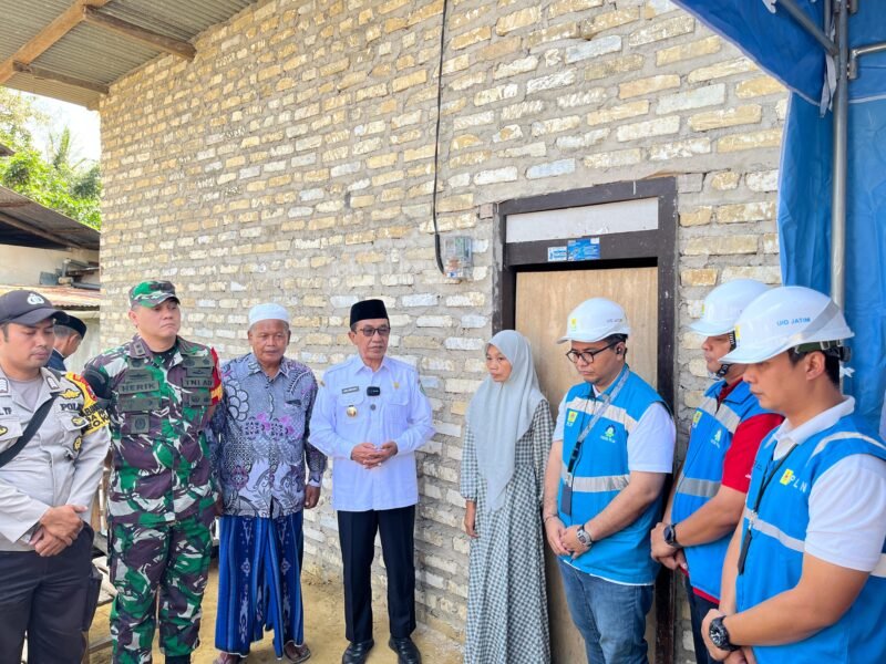 Bupati Pamekasan KH. Kholilurrahman (baju putih) didampingi Assistant Manager Keuangan dan Umum PLN UP3 Madura, Kharisma Nur Khakim berbincang usai penyerahan bantuan secara simbolis kepada Kamilah, guru honorer asal Desa Pamaroh, Kecamatan Kadur, Pamekasan. (KLIKMADURA)