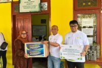 Manajer PLN UP3 Madura, Fahmi Fahresi menyerahkan bantuan secara simbolis kepada Kepala SLB PGRI Pademawu, Pamekasan. (MOH. IQBALUL KHAVEI MZ / KLIKMADURA)