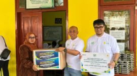 Manajer PLN UP3 Madura, Fahmi Fahresi menyerahkan bantuan secara simbolis kepada Kepala SLB PGRI Pademawu, Pamekasan. (MOH. IQBALUL KHAVEI MZ / KLIKMADURA)