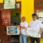 Manajer PLN UP3 Madura, Fahmi Fahresi menyerahkan bantuan secara simbolis kepada Kepala SLB PGRI Pademawu, Pamekasan. (MOH. IQBALUL KHAVEI MZ / KLIKMADURA)