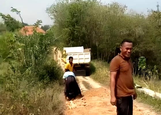 Warga Dusun Barat, Desa Gunung Kesan, Kecamatan Karangpenang, Sampang saat memperbaiki jalan rusak secara swadaya. (MUKSIN IKSAN / KLIKMADURA)