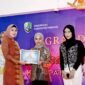 Ketua TP PKK Sampang Evi Slamet Junaidi menyerahkan sertifikat apresiasi kepada perwakilan Elysia Estetika Sampang saat malam Grand Final Putra Putri Batik Sampang 2025 yang digelar di Aula Pendopo Bupati Sampang, Sabtu malam (4/10/2025). (KLIKMADURA)