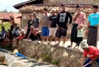 Warga Dusun Gunung Timur, Desa Gunung Kesan, Kecamatan Karang Penang, Kabupaten Sampang saat memperbaiki jalan dengan dana swadaya. (ISTIMEWA)