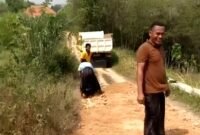 Warga Desa Gunung Kesan, Kecamatan Karang Penang, Sampang, saat melakukan perbaikan secara swadaya. (ISTIMEWA)