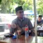 Bupati Pamekasan Dr. KH. Kholilurrahman menikmati kopi di warung kecil kawasan Undaan di sela-sela mendampingi istrinya yang menjalani operasi mata. (ISTIMEWA)