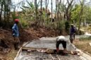 Sejumlah warga Desa Rongdalem, Kecamatan Omben, Kabupaten Sampang saat swadaya membangun jalan poros desa. (ISTIMEWA)