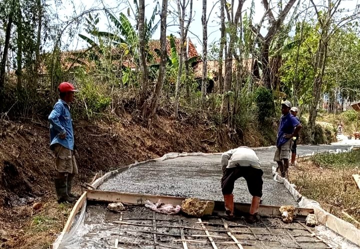 Sejumlah warga Desa Rongdalem, Kecamatan Omben, Kabupaten Sampang saat swadaya membangun jalan poros desa. (ISTIMEWA)