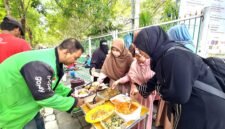 Anggota Hijabi Madura saat memberikan nasi kepada kang ojek pada program pemberian sarapan gratis di sisi timur Taman Arek Lancor, Pamekasan. (KLIKMADURA)