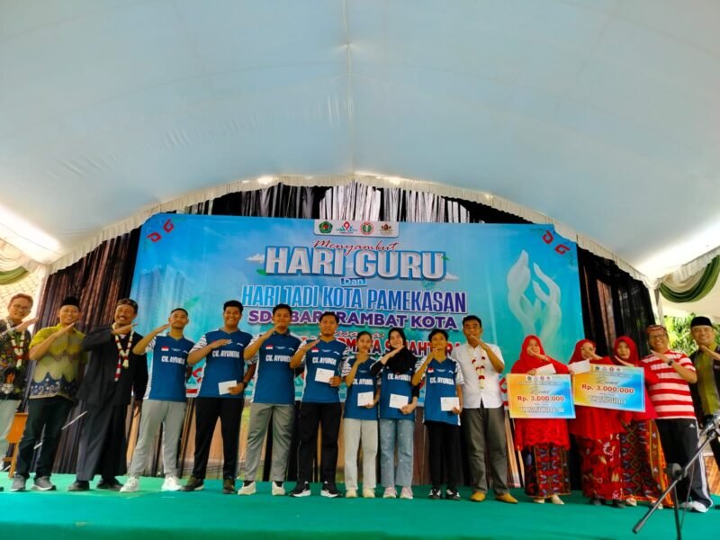 Founder CV. Ayunda Permata Sejahtera, Bambang Budianto (baju putih) bersama Kadisdikbud Pamekasa, Moh. Alwi (baju sakera) foto bersama para atlet bulu tangkis di SDN Barkot 3 usai pagelaran pesta rakyat. (LAILIYATUN NURIYAH/KLIK MADURA)