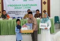 Ketua Baznas Sumenep, Abd. Rahman menyerahkan santunan kepada anak yatim. (DOK. KLIKMADURA)