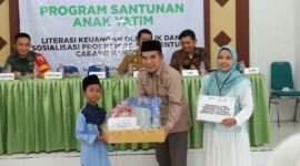 Ketua Baznas Sumenep, Abd. Rahman menyerahkan santunan kepada anak yatim. (DOK. KLIKMADURA)