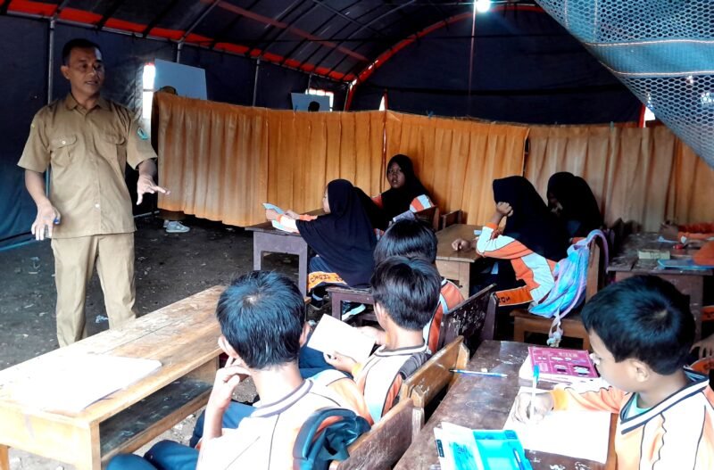 Siswa-siswi SDN Tamberu 2 saat mengikuti kegiatan pembelajaran di bawah tenda akibat sekolah disegel. (ISTIMEWA)