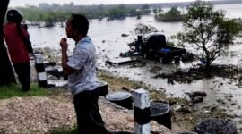Warga melihat kondisi mobil yang nyemplung ke area laut di Kecamatan Camplong, Sampang. (IBNU ANSORI / KLIKMADURA)