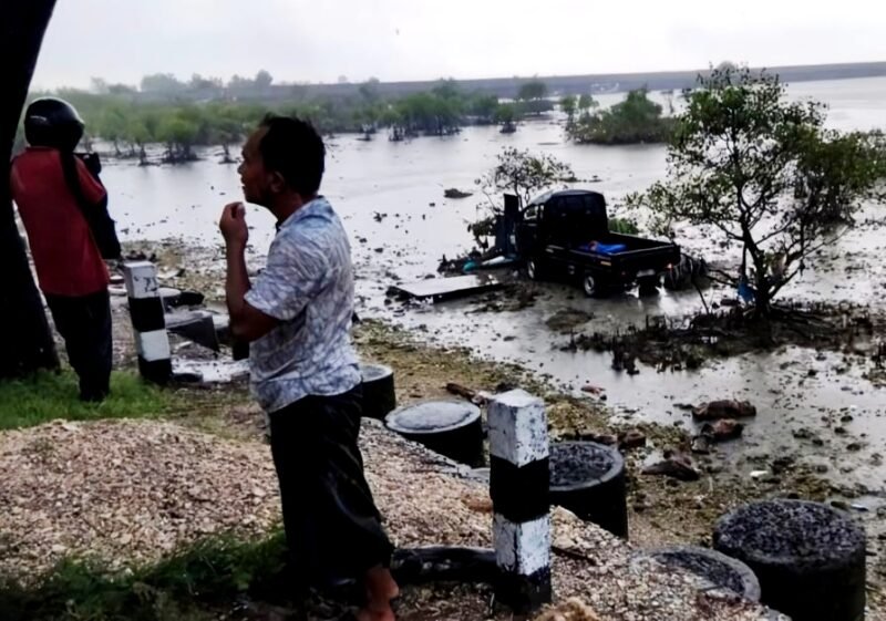 Warga melihat kondisi mobil yang nyemplung ke area laut di Kecamatan Camplong, Sampang. (IBNU ANSORI / KLIKMADURA)
