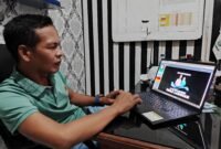 Kepala Desa Labuhan, Kecamatan Sreseh, Kabupaten Sampang, Jawahir menunjukkan aplikasi Simdes Labuhan Manis. (PRENGKI WIRANANDA / KLIKMADURA)