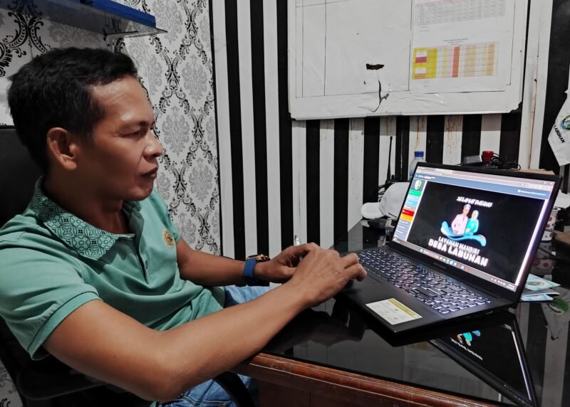 Kepala Desa Labuhan, Kecamatan Sreseh, Kabupaten Sampang, Jawahir menunjukkan aplikasi Simdes Labuhan Manis. (PRENGKI WIRANANDA / KLIKMADURA)