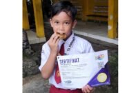 Raihan Khalid Alghifari, siswa SDI Plus Nurul Hikmah Pamekasan menunjukkan sertifikat dan medali emas. (DOK. KLIKMADURA)