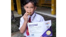 Raihan Khalid Alghifari, siswa SDI Plus Nurul Hikmah Pamekasan menunjukkan sertifikat dan medali emas. (DOK. KLIKMADURA)