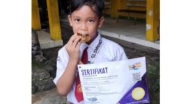 Raihan Khalid Alghifari, siswa SDI Plus Nurul Hikmah Pamekasan menunjukkan sertifikat dan medali emas. (DOK. KLIKMADURA)