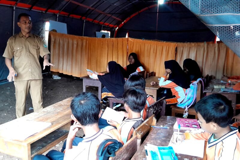 Siswa-siswi SDN Tamberu 2 Kecamatan Batumarmar, Pamekasan tetap semangat mengikuti kegiatan pembelajaran di bawah tenda dadurat. (DOK. KLIKMADURA)
