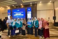 Srikandi PLN UP3 Madura foto bersama Dr. Elly Risman usai mengisi seminar nasional yang digelar Klik Madura di Ballroom Azana Style Pamekasan. (MOHAMMAD IQBALUL KHAVEI / KLIKMADURA)