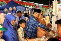 Pengawas SD Wilayah Kota Pamekasan, Nurul Huda didampingi Kepala SDI Al-Munawarah Pamekasan, Ustadzah Dedeh Rosidah mengunjungi stand bazar siswa. (DOK. KLIKMADURA)